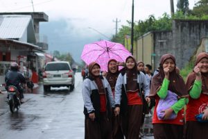 Siswa kelas 6 SD Ta'mirul Islam Surakarta berjalan menuju Pasar Tawangmangu melewati jalan yang basah sehabis hujan